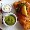 fish with slice of lemon and mushy peas