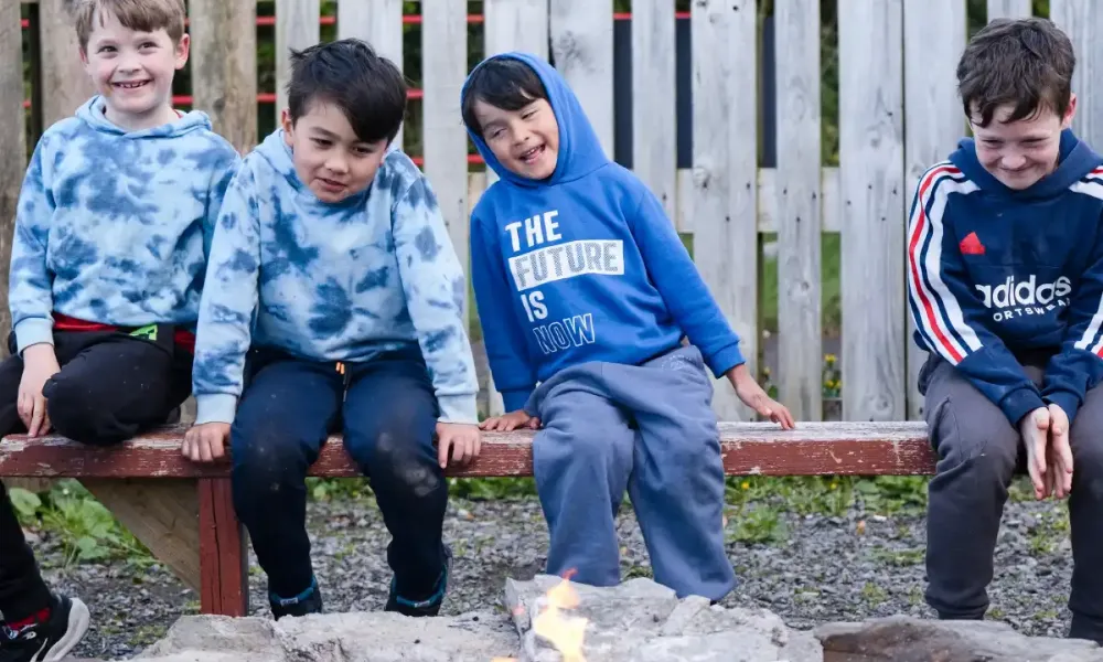 Kids sitting around communal fire pit at kids activities